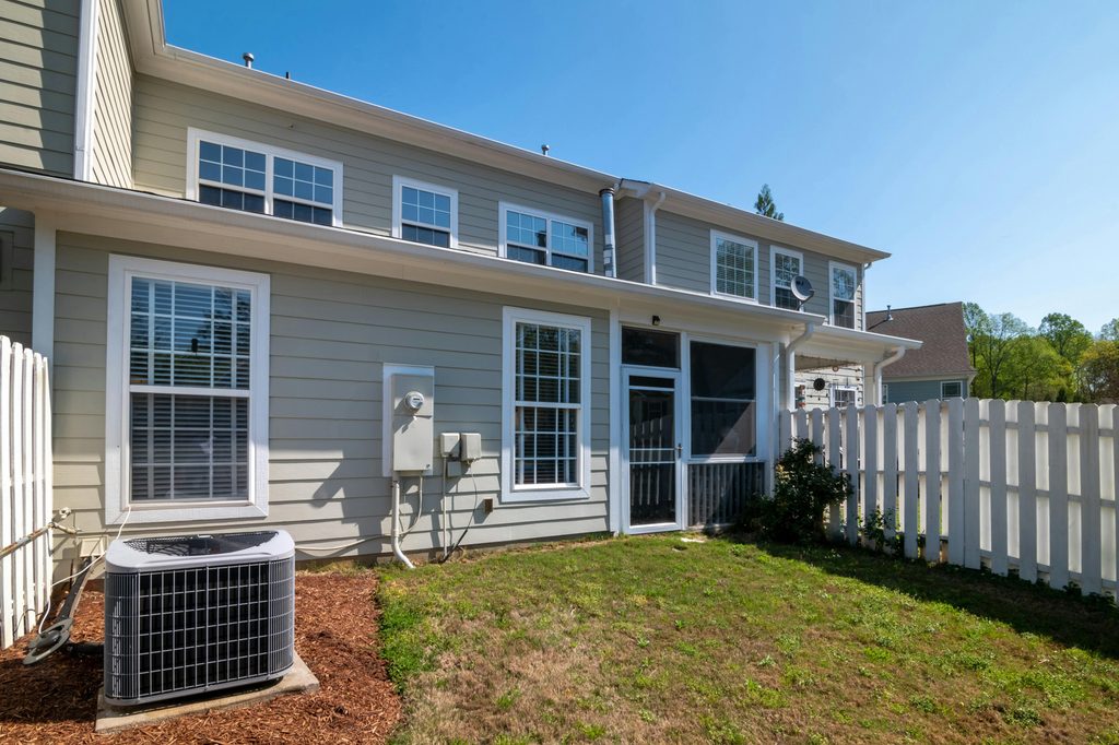 A back exterior of a house showing a condensing unit.